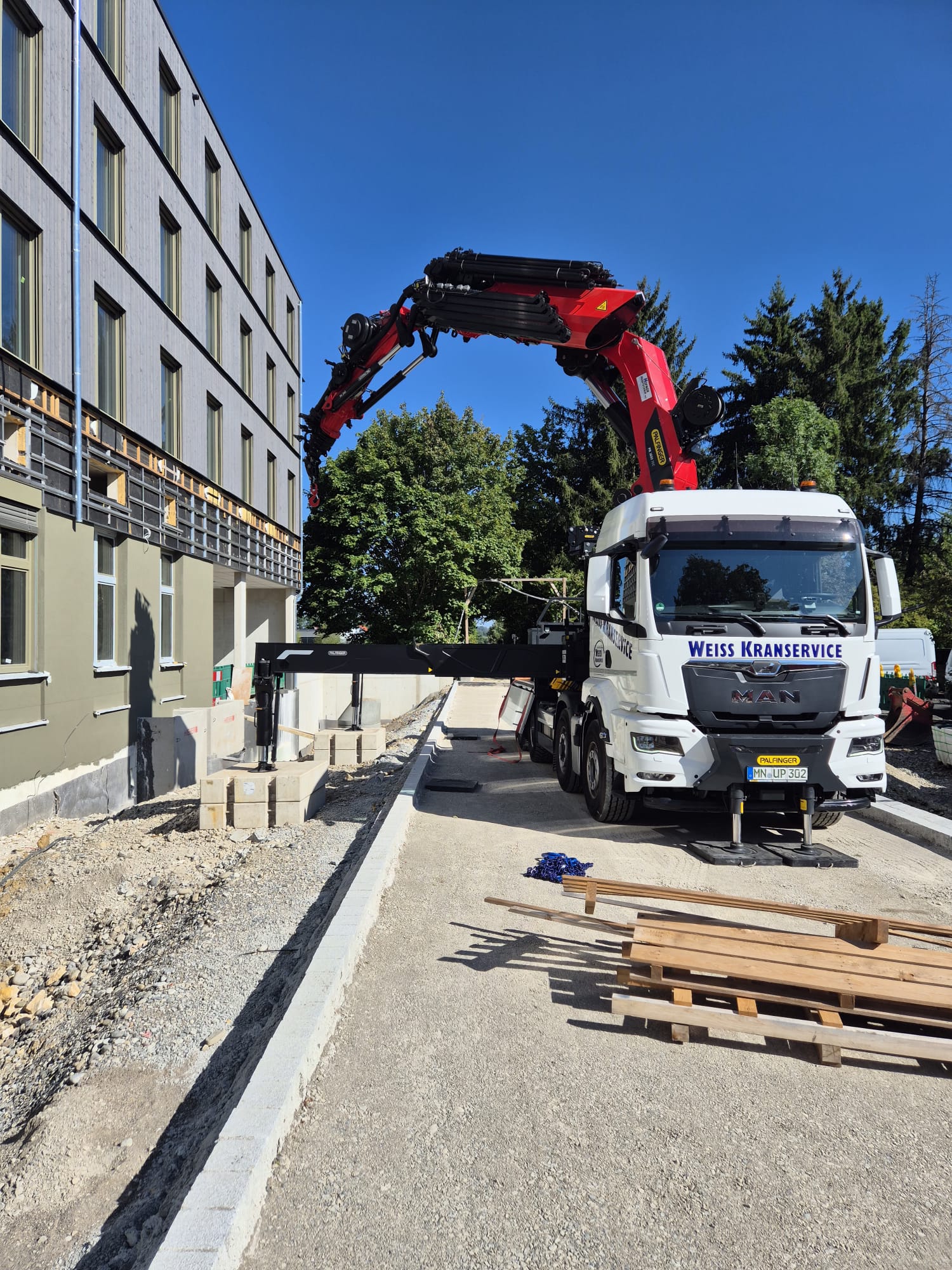 PALFINGER PK 1650 TEC bei einem Einsatz neben einem Gebäude